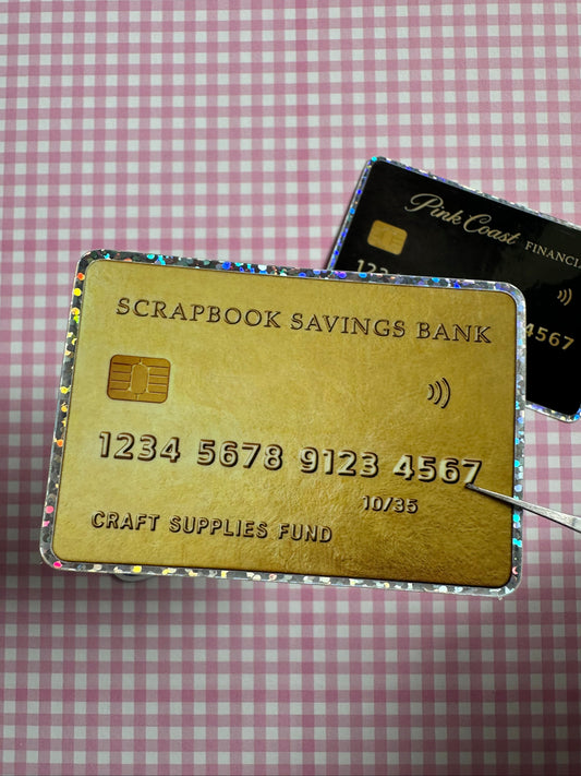 Gold credit card with text on a checkered background