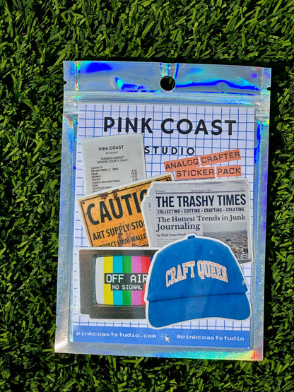 Pink Coast Studio sticker pack with a blue cap on a grass background